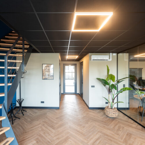 Zwart systeemplafond met glazen wand