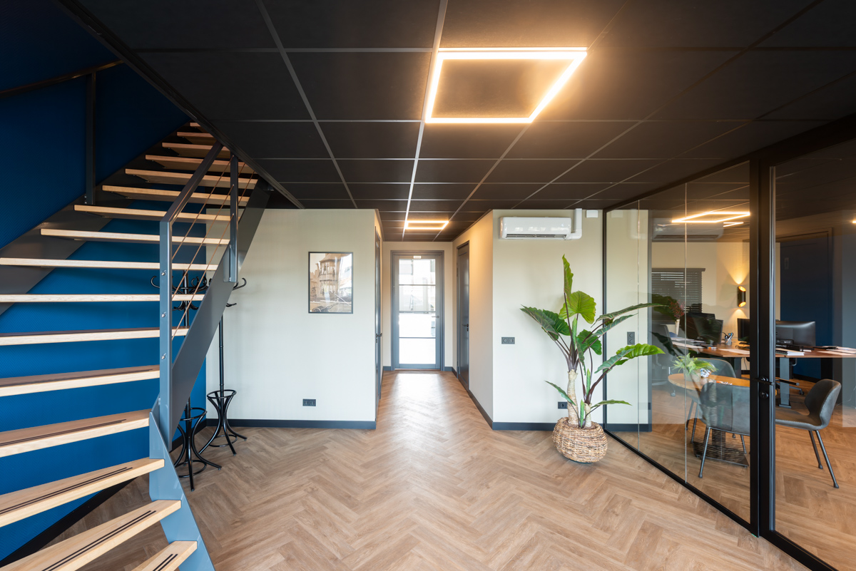 Glazen wand onder een zwart systeemplafond
