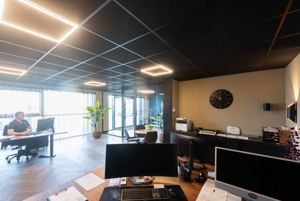 zwart systeemplafond met halo panelen in een kantoor